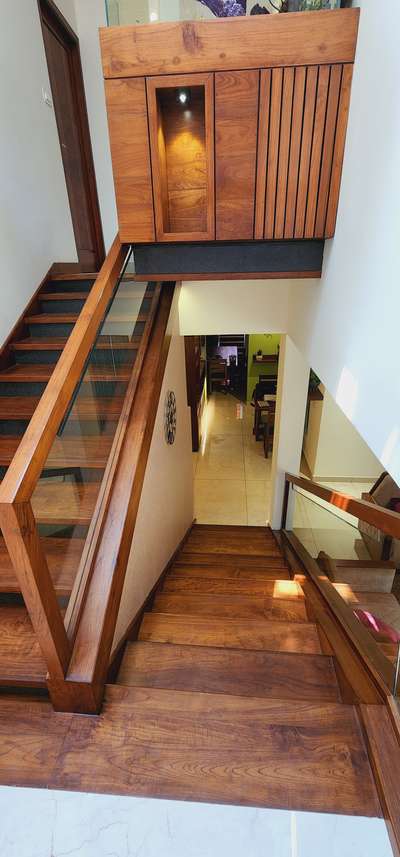 A stylish simple and elegant teak wood interior and landscape in a twin house. #woodenstair  #LivingroomDesigns  #LivingRoomTV  #GlassHandRailStaircase  #spotlight  #furnitures  #Landscape  #Sofas