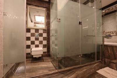 Bathroom interior with checkered wall tile and glass cubicle. #LUXURY_INTERIOR #BathroomTIles #BathroomDesigns