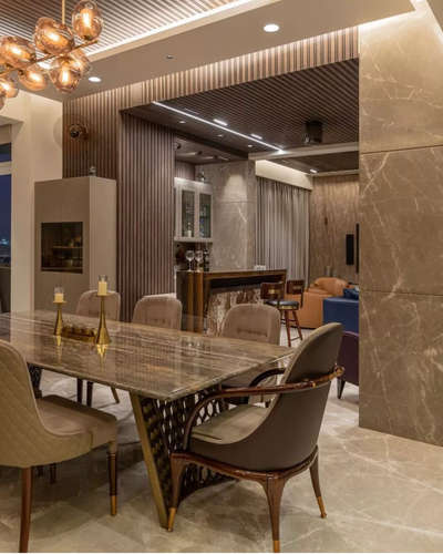 Bar area with dining with lavish design #DiningTable #bararea # stonedetail #wallpanelling #stonecarving #FalseCeiling #chandeliers #stonetable