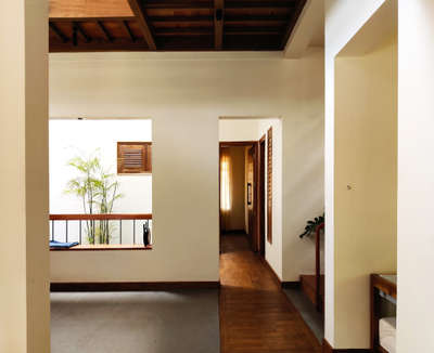 Traditional design home for a nuclear family.
The image shows wooden passage and view of a Courtyard. 
#TraditionalHouse  #slopedroofhouse  #