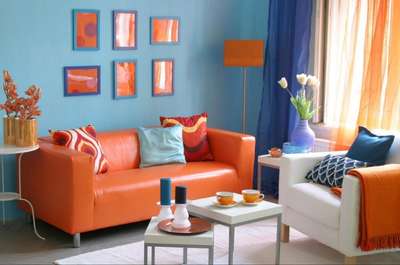 Go for a blue and orange combination by turning a simple blue space by adding orange and white sofas. Add curtains and cushions in blue and orange shades, while the rugs can be white. Go for sleek coffee tables and side tables, a tall vase, and simple framed artwork on the wall.  #interior  #decor  #ideas #home #interiordesign  #indian  #colourful #decorshopping