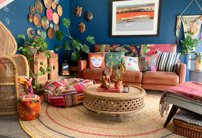 Put together a quirky boho decorated living room with printed cushion covers, multicolor floor cushion, wooden center table and lots of wall plates.#interior #decor #ideas #home #interiordesign #indian #colourful#decorshopping