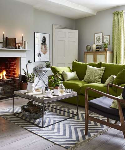 Get this green living room where the colour is used everywhere, from the furniture to the window treatments. Here, the sofas, cushions, curtains, vases and even the paintings are in shades of green. Add other wall decors, table decors and rug in shades of black, white and wood to match the colour combination. #interior #decor #ideas #home #interiordesign #indian #colourful