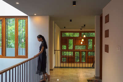 Bringing together a joint family amidst their traditional values and contemporary lifestyle by orchestrating spaces that celebrate and cherish life in all seasons and festivities, this project embraces Kerala vernacular architecture by the use of long Verandahs, Nadumuttam and Sloped Roof.
This abode is a cozy haven nested in a lush green setting abutting Paddy fields and Jathi-thottam merging its interiors to the site context. Like the classical raga which invites the rain, "MEGHAMALHAR" is a home which, like the people living in it, enjoys the rain and the beauty that it brings.

PROJECT DETAILS
Project Name: Meghamalhar
Location: Poikattussery, Angamaly Clients: Rohit_Reghunath Meera_Mohandas
Plot Area: 24 Cents
Built Area: 3444 sq.ft / 320 sq.m
Completion Year: 2024
Photo Credits: parallel frames 

 #tropicalminimalistic #kerlahouse #budgethomeconstruction #architectsinkerala