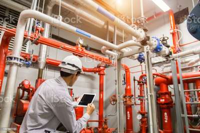 Engineer with tablet check red generator pump for water sprinkler piping and fire alarm control system. stock photo
