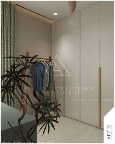 This modern utility or dressing room features full-height, handle-less white wardrobes with gold vertical handles, a wooden A-frame clothing rack, a large potted plant, and recessed lighting that creates a clean and minimalist aesthetic. #Architect  #architecturedesigns  #Architectural&Interior  #architectureldesigns  #best_architect  #architectsinkerala