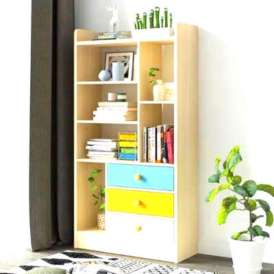 #Cabinet Description

Type: Multipurpose Bookshelf & Storage Cabinet
Material: Engineered Wood / MDF with a laminated finish
Color: Light wood tone with multicolored drawers (Blue, Yellow, White)
Design: Modern & Functional
Features

1. Open Shelving (Top Half):

7 Compartments for books, decor, or display items

Top row has both vertical and horizontal sections

Middle shelves are ideal for stacking books or placing small decor items



2. Drawers (Bottom Half):

3 Pull-Out Drawers:

Top Drawer: Blue front with yellow knob

Middle Drawer: Yellow front with white knob

Bottom Drawer: White front with yellow knob


Smooth sliding mechanism for everyday storage use



3. Vertical Space:

Ideal for fitting in living rooms, study rooms, bedrooms, or offices

Tall and slim design maximizes vertical storage



4. Decorative Top:

Flat top surface allows for additional decorative items like small figurines or plants



5. Base:

Solid base resting flat on the ground, providing stability