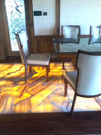 Flooring in dining and living rooms
Onyx marble stone is one of the most costly and elite semiprecious stones.The light is positioned in panels mounted behind thin marble or onyx slabs.
 #Onyxflooring #FlooringSolutions #onyxmarble  #interiorwork #villaproject #WallDesigns #DiningTableAndChairs #Ernakulam #kerala