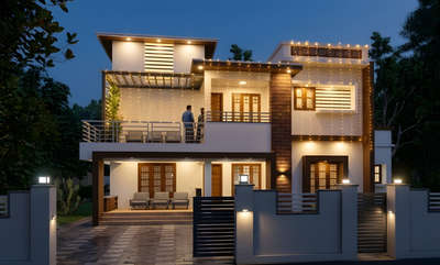 Aswathy Bhavan- Nestled in the tropical landscape of Kazhakuttom, Thiruvananthapuram, this east-facing 4-BHK residence is a rhythmic composition of crisp white planes and earthy brick textures. Designed as a sanctuary for light, the home greets the dawn with an elevated eastern balcony—a serene perch off the family living room dedicated to the client's daily Surya Namaskara.

The architecture balances this spiritual openness with practical modernism, featuring a tiered silhouette that reveals a west-facing sky terrace for play and utility. Inside, the spaces are interconnected by light-filled voids, where high-set clerestory windows and deep overhangs dance with the shifting shadows of the Kerala sun, creating a home that is both a functional retreat and a poetic tribute to the horizon.