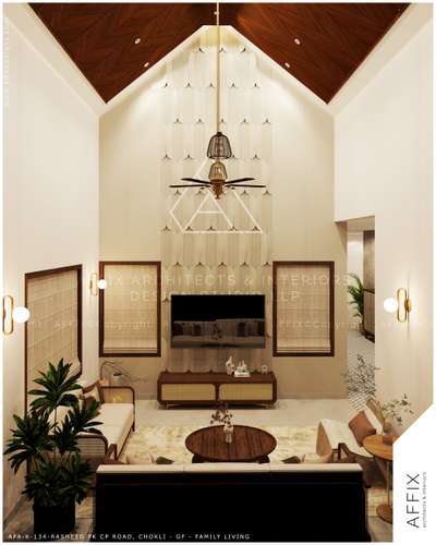 A family living room. It features a dramatic vaulted ceiling with dark wood paneling and a tall, textured accent wall that serves as a focal point. Simple architectural features like large windows and gold wall sconces make the space feel bright and open. The design uses rattan furniture and wooden accents to create a natural, modern vibe. It’s an airy, high-ceilinged space that feels comfirtness. #atchitecturedesign  #Architectural&Interior  #atchitecture  #kerala_architecture  #best_architect