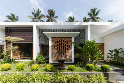 Mridul's Residence at Alappuzha is a four-bedroom single-story house with two courtyards at north and south. Hence, the height is increased to attain a proportionate mass. While sit-out is double height, a circular, open-to-sky glass roofed element is incorporated in the design. This feature acts as a visual focal point and helps create a dynamic composition of rounds and rectangles in the form.
The house is nestled within its natural surroundings, the exterior blending seamlessly with lush landscaping and varied brick patterns. Facing east, carefully placed perforations allow light to stream in.
The projected volume is the pooja room, surrounded by a water body on all sides and well-lit by a skylight. The pattern in longer brick wall brings in the light from the exterior into the inner courtyard. The bedroom and foyer offer a view of the courtyard, providing a sense of connection to the outdoors.

Project Details.
Project Name : Connecting Mango trees
Location : Kappil, alappuzha
Area : 4900 sq.ft.
Photohraphy: @syam.photographer
Completion Year : 2022
Manufacturing & Brands.
Flooring : somany | Q- Tile | Jaisalmer | vitrified Tiles | Ips
Wall cladding : Exposed Brick
Accessories & Interior Fixtures : Hettich India
Light Fixtures : Osram | Ledwell
Kitchen / Wardrobe : Reginox kitchen sinks
Bath fixtures : Kohler India
#cnsbuilders #residentialdesign #kayamkulam #tropicalmodernism #architecturedaily #architectureproject #architecturaldigest #architecturelovers #modernarchitecture #luxurymodern #designkerala #architectsneed