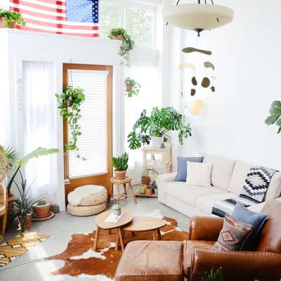 Create this modern boho living room with ivory sofa, boho printed cushions and rugs. Add jute ottoman and nesting wooden coffee table to complete the furniture set. Use lot of plants both potted and hanging to complete the look. #interior #decor #ideas #home #interiordesign #indian #colourful #decorshopping