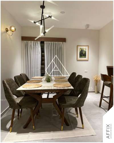 An elegant dining space featuring an Italian marble table with a teak wood frame, premium military green upholstered chairs, bamboo-inspired hanging lights, satin matte finish tiles, and premium curtains with sleek pelmets—designed to blend luxury and functionality seamlessly. #Architect  #architecturedesigns  #Architectural&Interior  #architectsinkerala  #best_architect