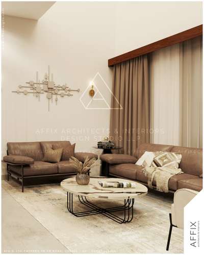 A warm, contemporary guest living space defined by earthy tones and refined materials. Plush fabric sofas in soft brown are paired with a marble-top center table and a textured area rug, creating a balanced seating arrangement. Neutral walls, wooden curtain pelmets, and layered drapery add depth, while subtle wall lighting and natural daylight enhance the calm, inviting ambience with understated elegance #Architect  #architecturedesigns  #Architectural&Interior  #architectureldesigns  #architectsinkerala  #best_architect  #LivingRoomDecoration