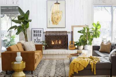 Create this inspiring cozy room: beautiful and comfortable at the same time. Place sofa on both sides of the coffee table, long potted plants near the fireplace, and a designer side table near the sofa. The overall shades of cushions, sofa, rugs, and walls gives a layer of autumn orange, brown and neutral tones.
#interior #decor #ideas #home #interiordesign #indian #colourful #decorshopping