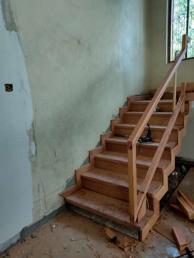 concrete staircase fully covered in mahogany, with glass and wood handrail