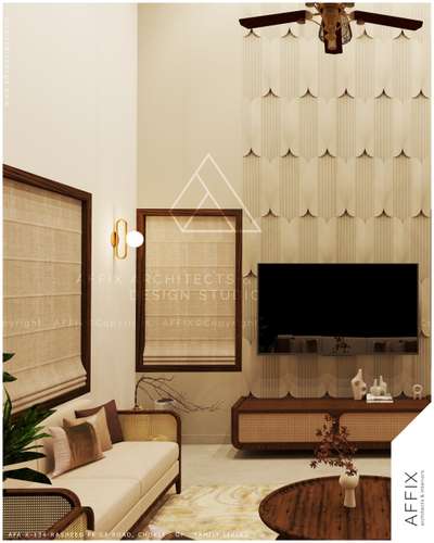 The room features a double-height textured panel wall behind the TV, contrasting with smooth beige walls, framed by dark wood cabinetry and windows with cane detailing, and lit by a brass sconce and an ornate ceiling fan. #Architect  #architecturedesigns  #Architectural&Interior  #architectureldesigns  #architecturekerala  #best_architect  #architecture_hunter