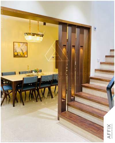 Seamless elegance meets functionality. This modern dining space is framed by a beautifully crafted wooden partition that defines the area without compromising openness. The warm wood tones, paired with luxurious flooring and a statement chandelier, create a perfect balance of sophistication and comfort. A flawless blend of materials enhancing the beauty of contemporary interiors. #Architect  #architecturedesigns  #Architectural&Interior  #architecturekerala  #best_architect