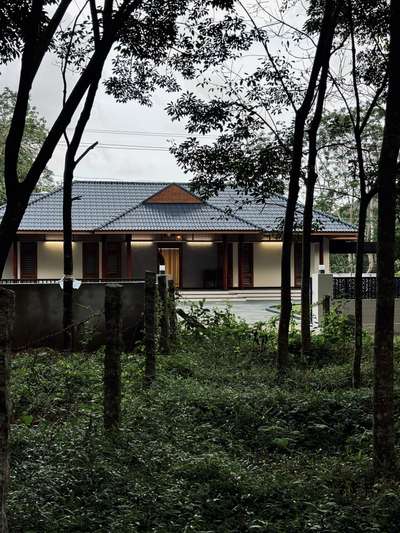 A contemporary take on traditional Kerala architecture, this residence brings together timeless proportions, pitched roofing, and warm wooden detailing with a refined modern sensibility. The long, symmetrical frontage opens into a calm and inviting central axis, creating a strong architectural presence rooted in regional context. Subtle material tones, deep verandah edges, and crafted lattice elements enhance both aesthetics and climate responsiveness.Developed in collaboration with PCA, the design blends tradition and modern comfort, creating a home that feels grounded, serene, and contextually connected.
2800 sqft | Client: Sibi | Location: Amboori, Trivandrum
#Architecture #KeralaArchitecture #ContemporaryTradition #ModernResidence #RegionalDesign #ArchitecturalDetails #CourtyardHome #TrivandrumHomes #koloprojects
