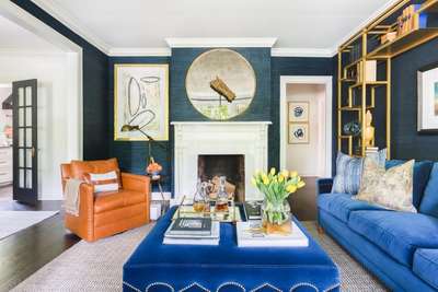 Get this dramatic blue and gold living room with royal blue and leather sofas, golden shelf , and a collection of table decors. Add abstract paintings and a round mirror to decorate your walls. #interior #decor #ideas #home #interiordesign #indian #colourful #decorshopping