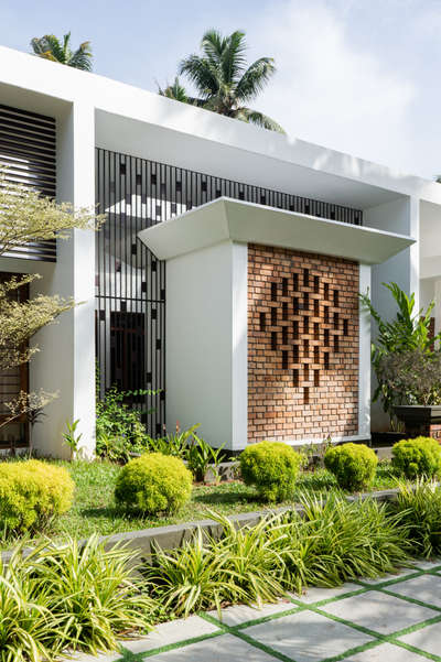 Mridul's Residence at Alappuzha is a four-bedroom single-story house with two courtyards at north and south. Hence, the height is increased to attain a proportionate mass. While sit-out is double height, a circular, open-to-sky glass roofed element is incorporated in the design. This feature acts as a visual focal point and helps create a dynamic composition of rounds and rectangles in the form.
The house is nestled within its natural surroundings, the exterior blending seamlessly with lush landscaping and varied brick patterns. Facing east, carefully placed perforations allow light to stream in.
The projected volume is the pooja room, surrounded by a water body on all sides and well-lit by a skylight. The pattern in longer brick wall brings in the light from the exterior into the inner courtyard. The bedroom and foyer offer a view of the courtyard, providing a sense of connection to the outdoors.

Project Details.
Project Name : Connecting Mango trees
Location : Kappil, alappuzha
Area : 4900 sq.ft.
Photohraphy: @syam.photographer
Completion Year : 2022
Manufacturing & Brands.
Flooring : somany | Q- Tile | Jaisalmer | vitrified Tiles | Ips
Wall cladding : Exposed Brick
Accessories & Interior Fixtures : Hettich India
Light Fixtures : Osram | Ledwell
Kitchen / Wardrobe : Reginox kitchen sinks
Bath fixtures : Kohler India
#cnsbuilders #residentialdesign #kayamkulam #tropicalmodernism #architecturedaily #architectureproject #architecturaldigest #architecturelovers #modernarchitecture #luxurymodern #designkerala #architectsneed