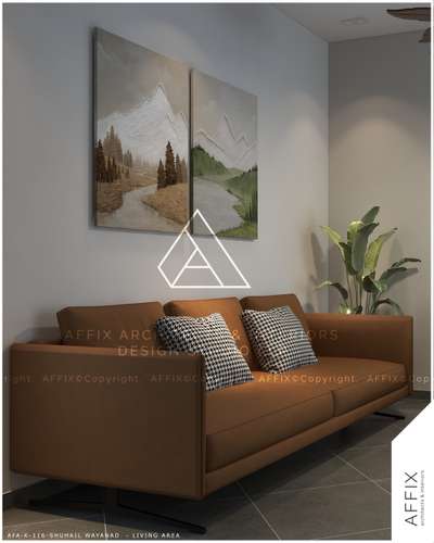 This warm, modern living space features a sleek tan leather sofa with hound's-tooth cushions, elegantly highlighted by a textured mountain diptych and a large plant, achieving a balance of minimalist design and cozy character. #Architect  #architecturedesigns  #Architectural&Interior  #architectsinkerala  #architectsinkerala   #best_architect  #LivingRoomDecors