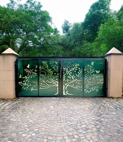 Steel gate renovation with custom nature-inspired CNC laser cuts and dark green finish.