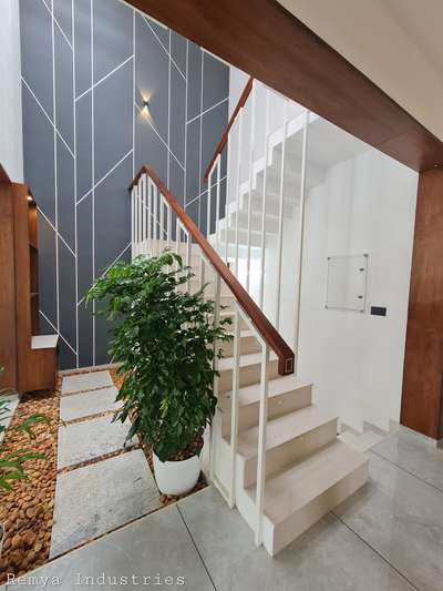 If your style leans traditional, the tailored look of a white-and-wood staircase railing design is perfect for  your home. Here, simple square baluster uprights are perked up with a rich stained wood handrail and treads. The simplicity of the design lets the crisp white finish and deep wood tones shine.
 #Woodenhandrail  #modernhandrails  #StaircaseHandRail  #handrailswood  #railingdesign