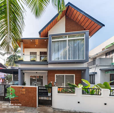 Meet Bhodhi. 
the 3BHK dream home of 
Dr. Ullas & Dr. Nimmi in Palakkad! 🏠✨ 
Designed by Arts Architects, completed in 2024.
Check out the sleek design with a mix of white, grey, and brown accents, surrounded by lush greenery 🌴.
Front view reveals a cozy balcony and a chic entrance.