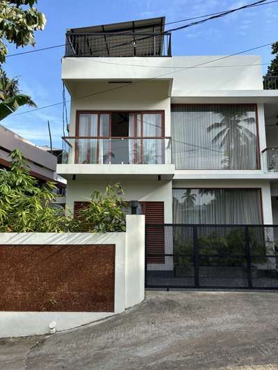 A refined contemporary residence defined by clean white volumes, full-height glazing, and warm wooden accents. The design emphasises openness and light, creating a calm architectural presence within the neighbourhood. Subtle material contrasts and linear forms come together to shape a modern home that feels both elegant and grounded.
Client: Arjun | 1750 sqft | Location: Trivandrum
#Architecture #ContemporaryResidence #ModernDesign #GlassFacade #UrbanHome #TrivandrumArchitecture #MinimalDesign #ArchitecturalDetails #koloprojects