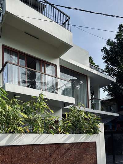 A refined contemporary residence defined by clean white volumes, full-height glazing, and warm wooden accents. The design emphasises openness and light, creating a calm architectural presence within the neighbourhood. Subtle material contrasts and linear forms come together to shape a modern home that feels both elegant and grounded.
Client: Arjun | 1750 sqft | Location: Trivandrum
#Architecture #ContemporaryResidence #ModernDesign #GlassFacade #UrbanHome #TrivandrumArchitecture #MinimalDesign #ArchitecturalDetails #koloprojects