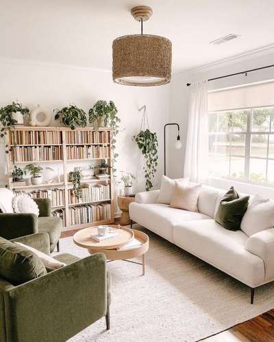 Create this aesthetic living room with Ivory and green sofas with matching cushions, white curtain and rug, white vases in different style and many lots of plants. The open wooden book shelf along the wall makes the room warmer. #interior  #decor  #ideas  #livingroom  #home  #interiordesign  #indian  #colourful #decorshopping