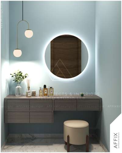 A glowing round mirror creates a beautiful halo effect, paired with sleek pendant lighting for a warm ambience. The floating wooden vanity keeps the look clean and space-efficient, while subtle decor and greenery add a touch of elegance. Finished with a compact upholstered stool and marble flooring for a refined, contemporary feel. #Architect  #architecturedesigns  #Architectural&Interior  #kerala_architecture  #architecture