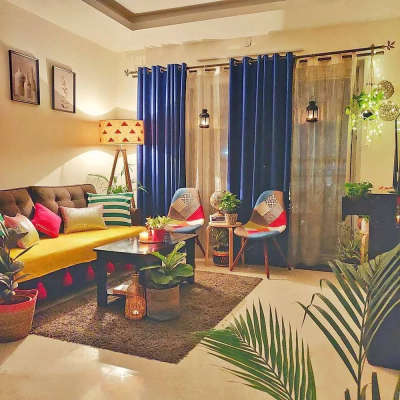 Create this colourful cozy vibe in the room with: Heavy blue curtains paired with sheer curtains, a brown furry rug, multicoloured chairs, a printed lampshade, sofa cover with tassles and a lot of cushions, fairy lights and some plants.
#interior #decor #ideas #home #interiordesign #indian #colourful #decorshopping
