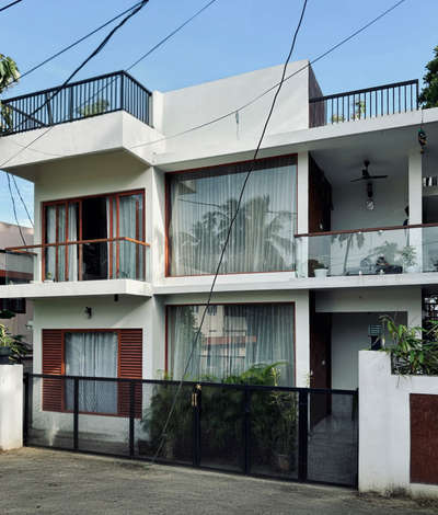A refined contemporary residence defined by clean white volumes, full-height glazing, and warm wooden accents. The design emphasises openness and light, creating a calm architectural presence within the neighbourhood. Subtle material contrasts and linear forms come together to shape a modern home that feels both elegant and grounded.
Client: Arjun | 1750 sqft | Location: Trivandrum
#Architecture #ContemporaryResidence #ModernDesign #GlassFacade #UrbanHome #TrivandrumArchitecture #MinimalDesign #ArchitecturalDetails #koloproject