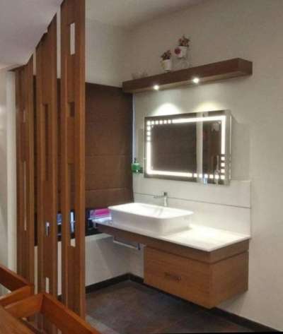 simple wash basin counter 
nano white counter top 
counter top basin and pillar tap from jaguar
cabinets with multi wood
customised mirror with led