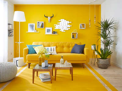 Create a warm and inviting living room by adding a yellow sofa to the yellow-painted space. Balance the colour by using coffee tables, floor lamps, ottomans, and wall decors in white shade. Add planters to give a fresh and cheerful vibe to the space. #interior  #decor  #ideas  #home  #interiordesign  #indian  #colourful #decorshopping