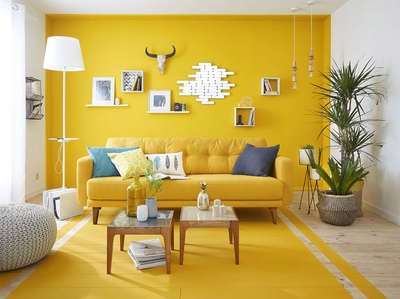 Create a warm and inviting living room by adding a yellow sofa to the yellow-painted space. Balance the colour by using coffee tables, floor lamps, ottomans, and wall decors in white shade. Add planters to give a fresh and cheerful vibe to the space. #interior  #decor  #ideas  #home  #interiordesign  #indian  #colourful #decorshopping