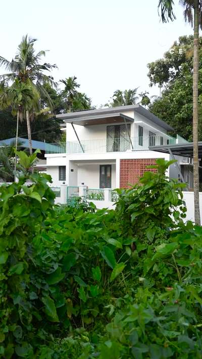 Project Overview – Residence Renovation in Vamanapuram, Thiruvananthapuram

Set in the lush green surroundings of Vamanapuram, this 23-year-old residence—home to a family of five—underwent a thoughtful transformation to meet the evolving needs of its inhabitants. The original structure had low ceilings, underutilized side setbacks, and minimal natural light, which made the rooms feel cramped and disconnected. Common spaces were lacking, and a single toilet served the entire house.

The renovation focused on redefining spatial experience while retaining a sense of rootedness. Each bedroom now has an attached toilet, significantly improving comfort and privacy. A compact yet serene puja space was introduced adjacent to the sit-out, featuring a traditional jali screen that filters light and maintains a sense of calm seclusion.

Modern aesthetics were balanced with minimal traditional elements—clean lines, square geometries, and muted color palettes in white, grey, and soft blues. A pergola above the staircase brings in much-needed sunlight, visually expanding the core and adding vibrancy throughout the day.

This reimagining brings new life to the home, making it more responsive to the family’s current lifestyle while subtly preserving its emotional ties to the past. #HouseRenovation  #InteriorDesigner  #homeinterior