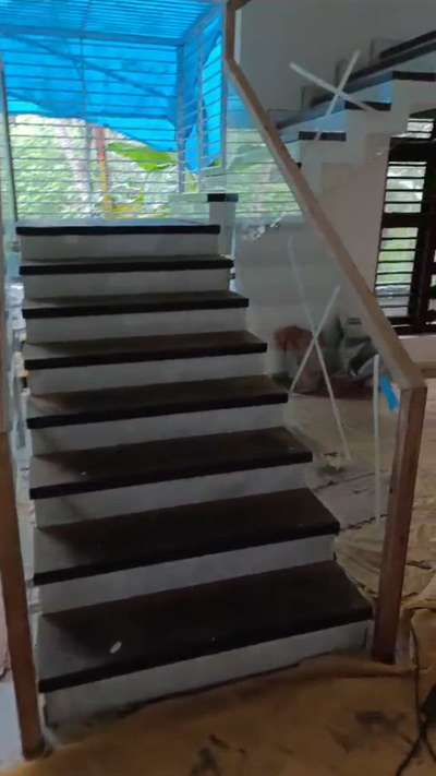 Glass stair railing 
Railing Type: Frameless Glass Railing

Glass Thickness: 12mm Toughened (Clear / Tinted)

Handrail: Solid Wood (Often Teak, Mahogany or Engineered Wood)

Mounting System: Side-mounted Stainless Steel Spigots / Patch Fittings

Design Use: Staircase / Balcony / Mezzanine

Style: Minimalist, Floating, Modern Look
 #GlassHandRailStaircase #GlassBalconyRailing #InteriorDesigner #modernhouse #glassrailings #Thrissur #HomeDecor #Designs #Toughened_Glass