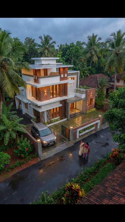 1850 sqft modern home in the middle of Kerala greenery 🌿🏡
Rainy evening + warm lights = perfect vibe ✨ # Kerala Home design #keralaarchitectures #KeralaStyleHouse #keraladesigns
